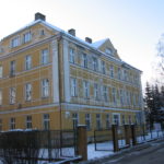 Zdjęcie przedstawia budynek po zamkniętym Zespole Szkół w Pieszycach od strony ul. Mickiewicza. Budynek ma fasadę w kolorze żółtym.