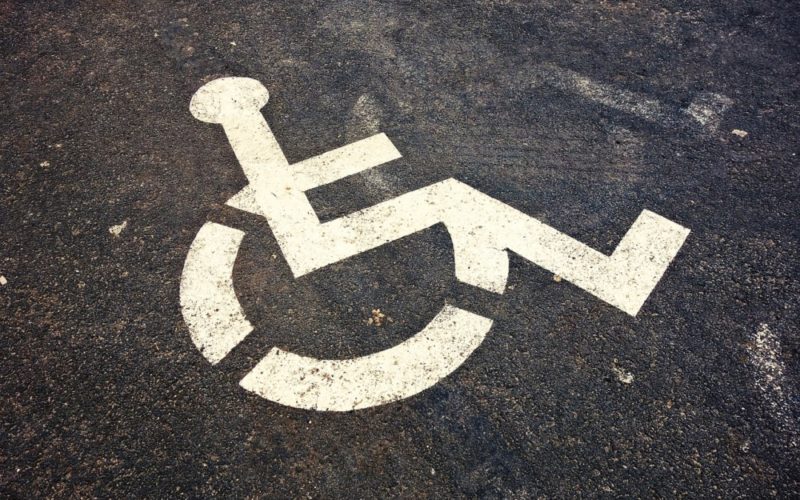 Zdjęcie fragmentu ulicy z namalowanym farbą symbolem osoby siedzącej na wózku inwalidzkim