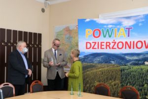 Sala konferencyjna. Przewodniczący Rady Powiatu i Starosta Dzierżoniowski wręczają podziękowania przedstawicielowi sztabu WOŚP