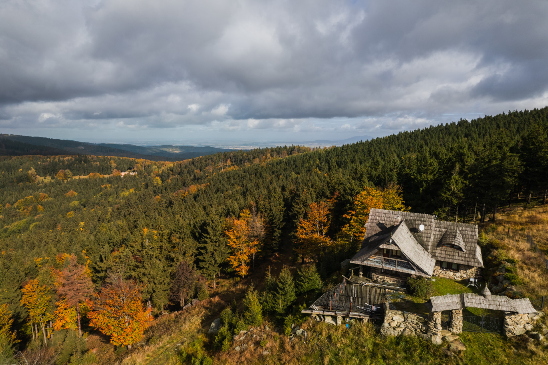 jesienny widok z Kalenicy, na pierwszym planie kamienno-drewniane gospodarstwo położone w górach.