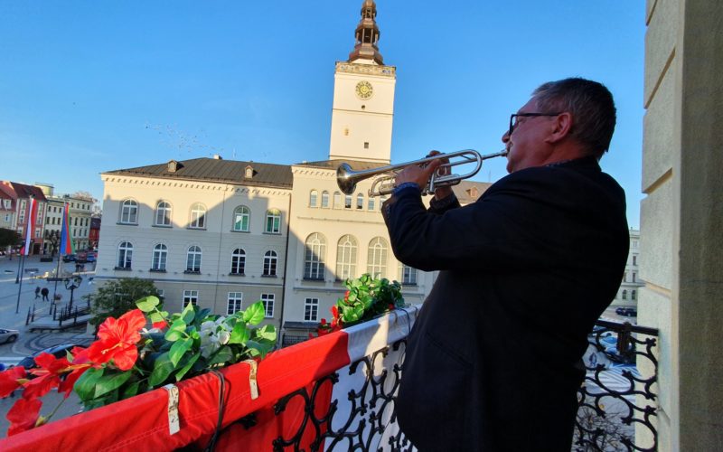 Tadeusz Nestorowicz na balkonie gra hejnał. W tle wieża ratuszowa um Dzierżoniów