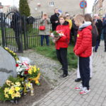 Młodzież szkolna składa kwiaty pod obeliskiem