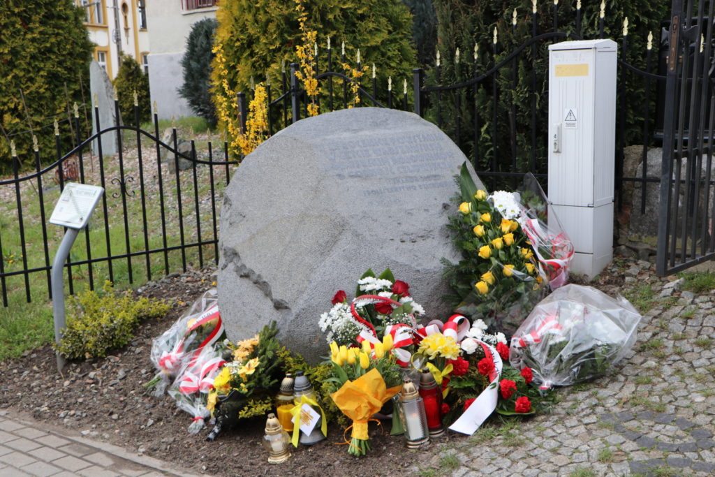 Złożone kwiaty przy obelisku pod Synagogą w Dzierżoniowie