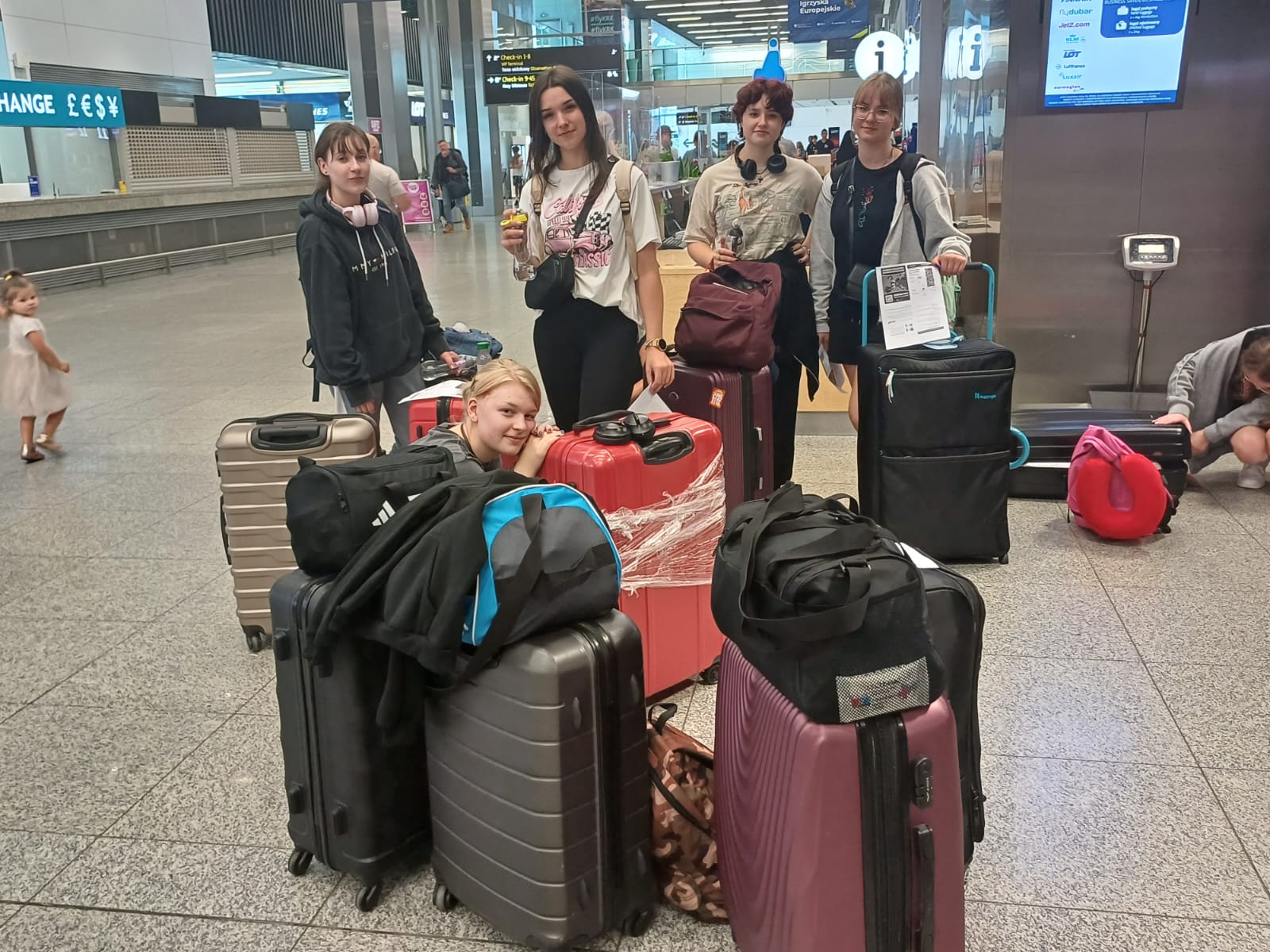 uczniowie z walizkami na lotnisku