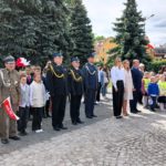władze miasta, policji i wojska wraz z dziećmi składający kwiaty pod pomnikiem w dniu narodowego zwycięstwa