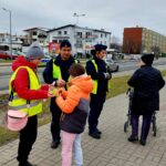 policjanci wraz z przedstawicielem młodzieżowego zespołu rozdający odblaski 3