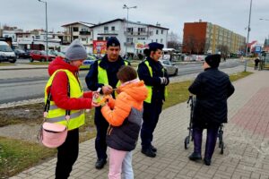 policjanci wraz z przedstawicielem młodzieżowego zespołu rozdający odblaski 3