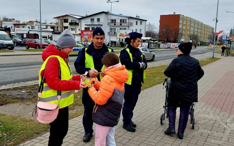 policjanci wraz z przedstawicielem młodzieżowego zespołu rozdający odblaski 3