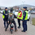 policjanci wraz z przedstawicielem młodzieżowego zespołu rozdający odblaski panu na hulajnodze