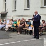 ludzie siedzą, mężczyzna przemawia