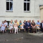 nauczyciele i goście siedzą na krzesłach