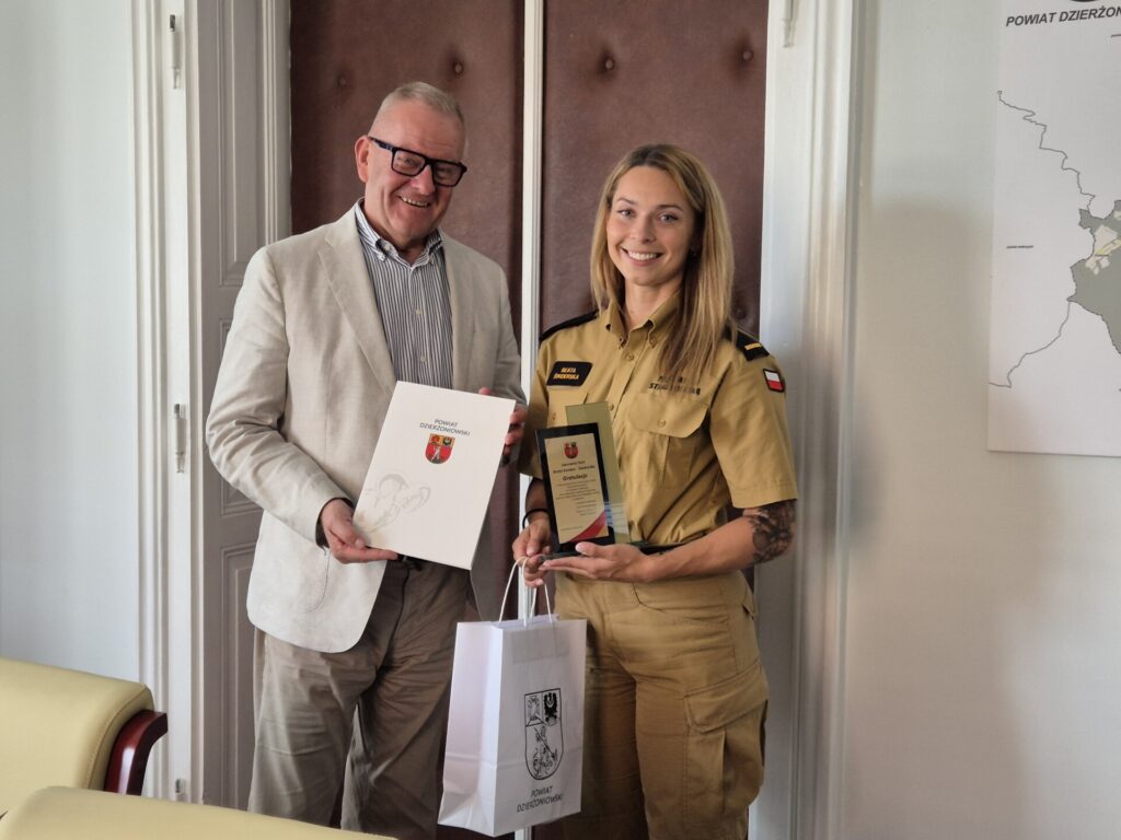 Starosta i strażaczka Beata Świderska z upominkami od powiatu