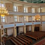 Wnętrze Kościoła Maryi Matki Kościoła ławki i balkony.