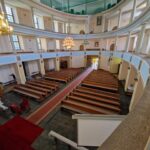 Wnętrze Kościoła Maryi Matki Kościoła ławki i balkony.