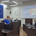 Powiatowa Rzecznik Konsumentów przedstawia prezentacje, w tle radni i zarząd powiatu