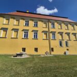 Pałac w Kiełczynie z zewnątrz, tył pałacu, krzyż pokutny i studnia