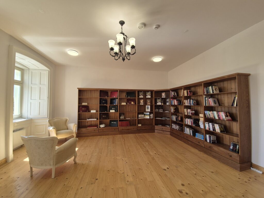 Sala biblioteczna, regał z książkami i krzesła