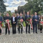 przedstawiciele samorządów stoją z kwiatami