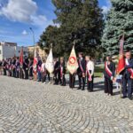 poczty sztandarowe i uczniowie stoją na placu