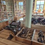 zbiory muzeum sprzęt do zegarów, w tle świnki w gablotach