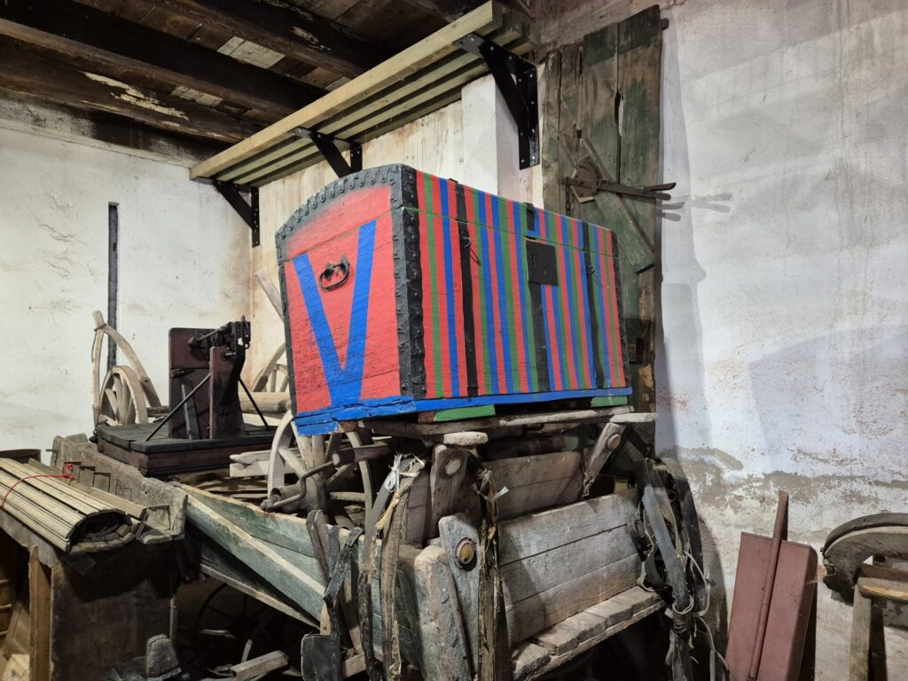 kolekcja eksponatów w muzeum w Kamionkach, czerwono-niebiesko-zielona skrzynia drewniana
