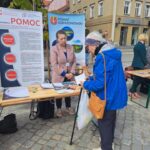 ludzie stoją przed stoiskiem nieodpłatnej pomocy prawnej