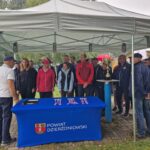 uczestnicy regat stoją, przed nimi stół z medalami