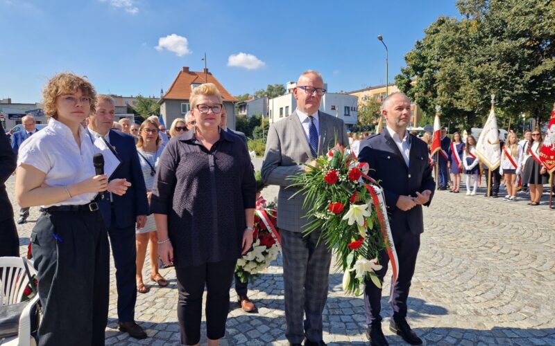 przedstawiciele Zarządu Powiatu z kwiatami, za nimi pozostali uczestnicy obchodów