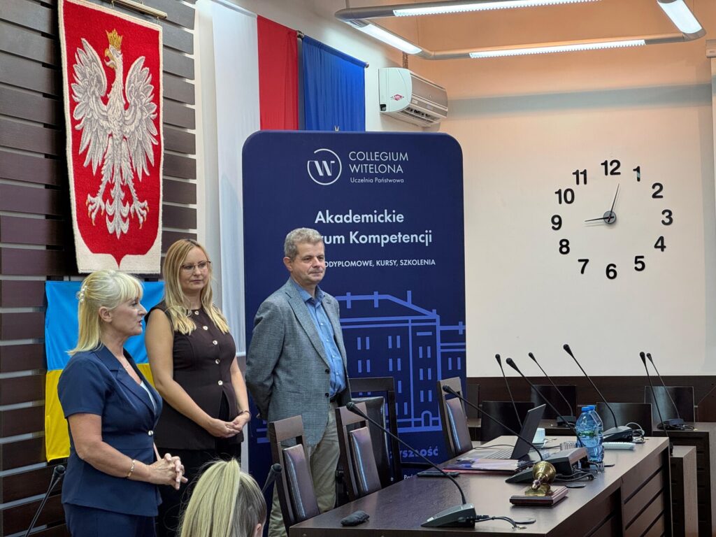 trzy osoby stoją przed stołem