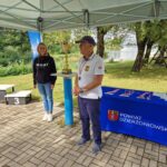 sekretarz i przedstawiciel BKŻ stoją przy stole z medalami i obok pucharu