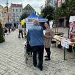 ludzie stoją przed stoiskiem nieodpłatnej pomocy prawnej