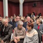 ludzie siedzą na krzesłach, za nimi starosta i poseł