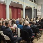 ludzie siedzą na krzesłach