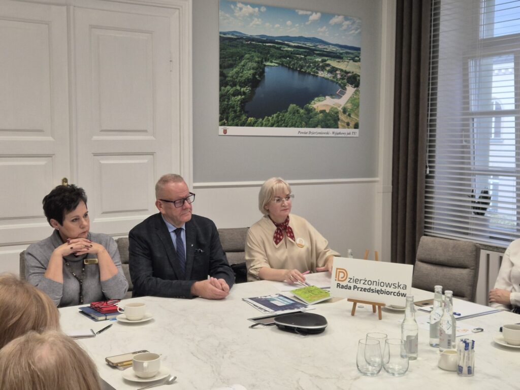 starosta, dyrektor wydziału edukacji i radna miasta siedzą przy stole