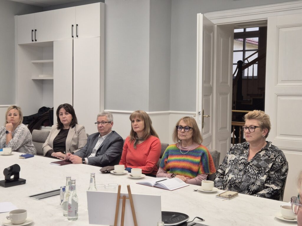 ludzie siedzą przy stole, widok na drzwi