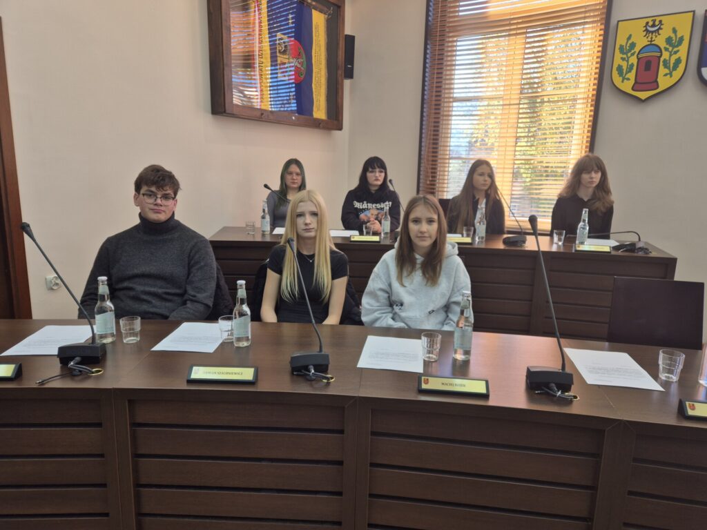 młodzież przy stoliku na sali sesyjnej