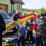 Młodzież stoi przy poszkodowanym obok samochodu