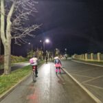 jedna osoba jedzie na rowerze, druga na rolkach