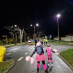 kobieta i dziewczynka w różowych strojach jadą na rolkach