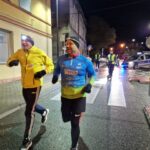 dwóch mężczyzn biegnie ulicą w strojach biegowych