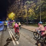 uczestnicy jadą na rowerach w różowych strojach i z balonami