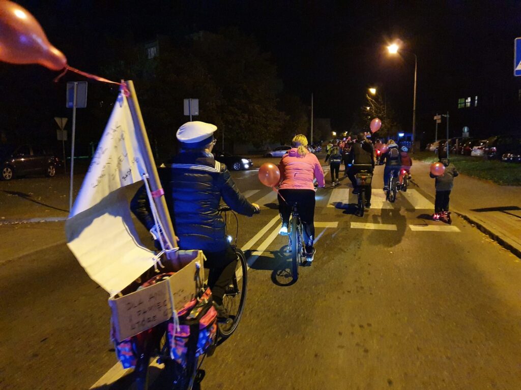 osoba na rowerze w przebraniu marynarza, z przodu inne osoby