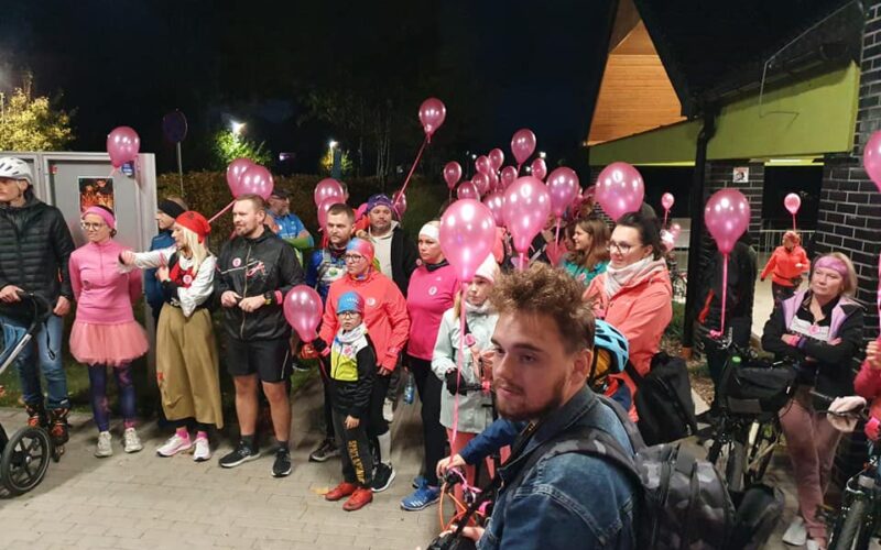 ludzie z różowymi balonami stoją, niektórzy w przebraniach