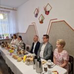 starosta i burmistrz siedzą przy stoliku obok kierowniczka