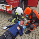 strażacy udzielają pomocy poszkodowanemu