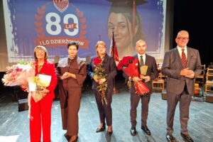 starosta, wicestarosta, dyrektor ILO, dyrektor wydziału edukacji i przewodnicząca komisji edukacji stoją na scenie z kwiatami