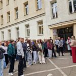 widok na uczniów stojących pod szkołą