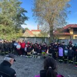 grupa ludzi, uczestnicy ćwiczeń stoją razem na placu