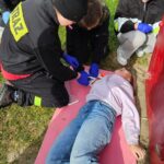 MDP w strojach straży podczas ćwiczeń, jedna osoba leży na ziemi