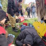 grupy młodzieży z mdp i osp podczas ćwiczeń, na ziemi leży poszkodowany
